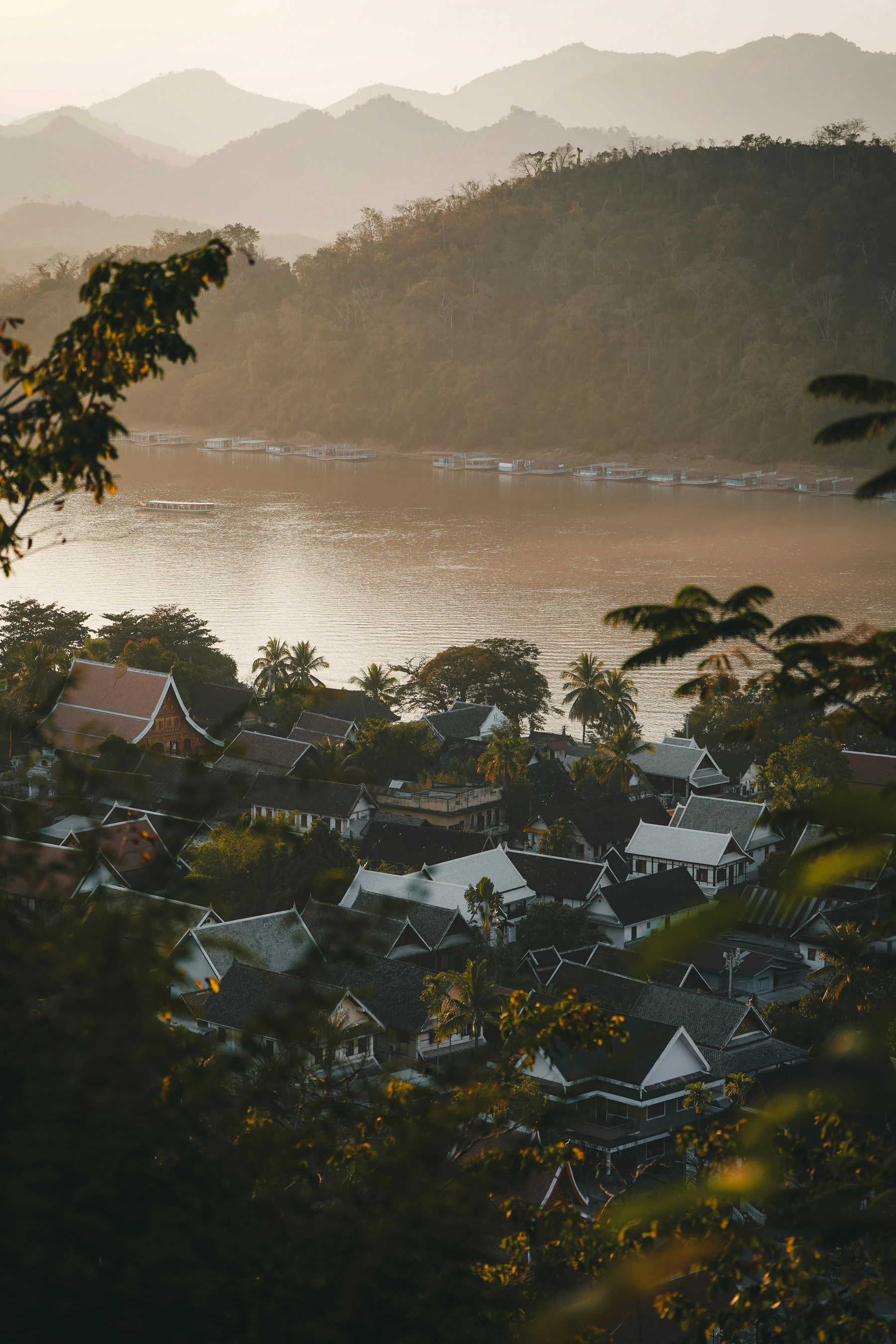 Le Mékong, les montagnes et les maisons traditionnelles au soleil couchant